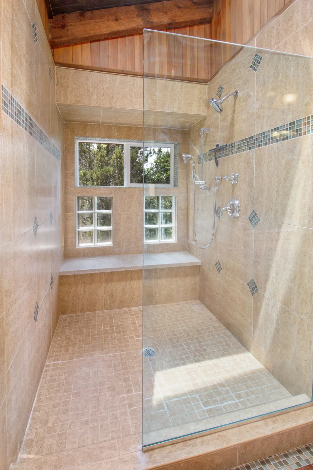 Spacious, elegant shower with glass doors and natural light for a contemporary home feel