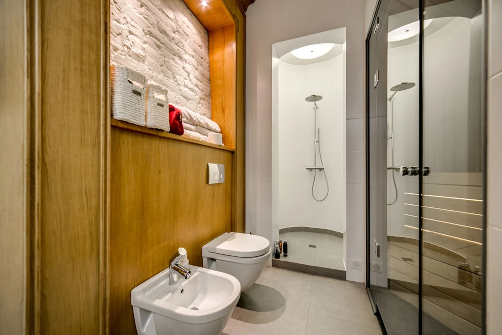 A contemporary bathroom featuring a bidet, toilet, and an elegant shower area