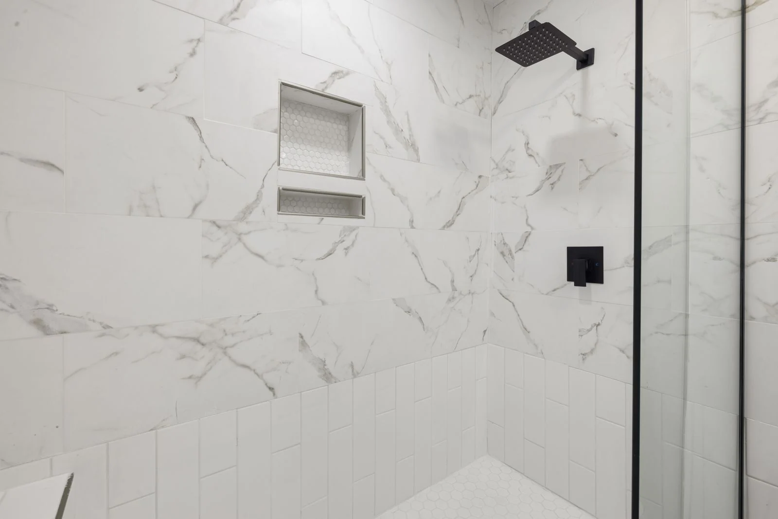 White shower tiles and recessed shelves