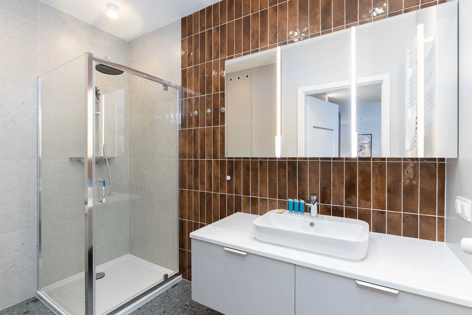 Contemporary bathroom interior featuring a glass shower and sleek vanity unit